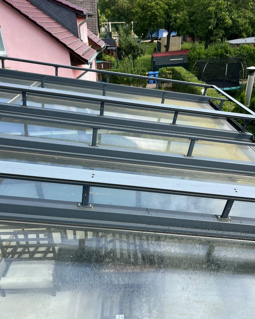 Glasdach eines Wintergartens in Berlin vor der Reinigung mit Wetterschleier und Grünbelag